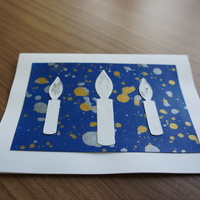 Candles on Blue: white candles over a speckled blue canvas.