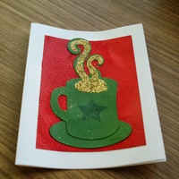 Holiday Mug: Green mug with a dark green star, golden steam, on a red field.